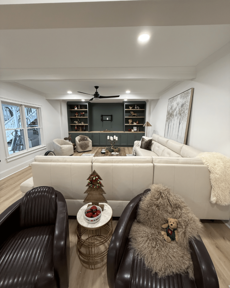 Spacious basement media room in Alpharetta featuring a custom dark green built-in entertainment center.