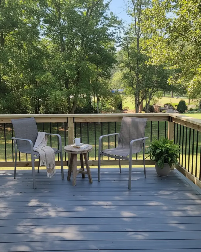 Grey composite decking featuring natural wood railings with contrasting black metal spindles in an Alpharetta backyard.