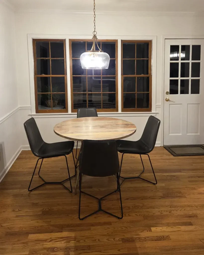 Cozy eat-in kitchen breakfast nook with a round table and backyard window view.