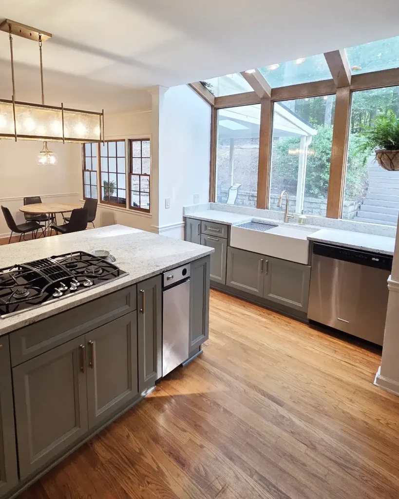 Bright kitchen renovation in North Atlanta featuring a white apron front sink and large sunroom windows.