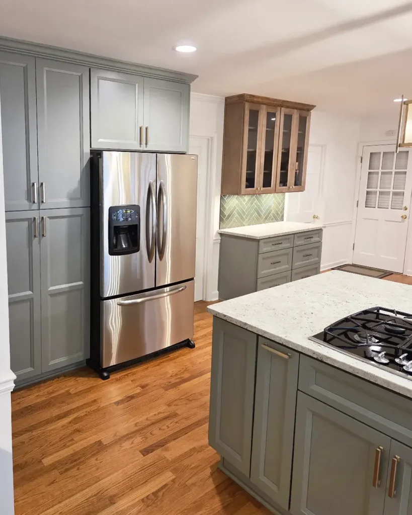 Floor-to-ceiling green custom pantry cabinets and refrigerator surround installed by local remodelers.