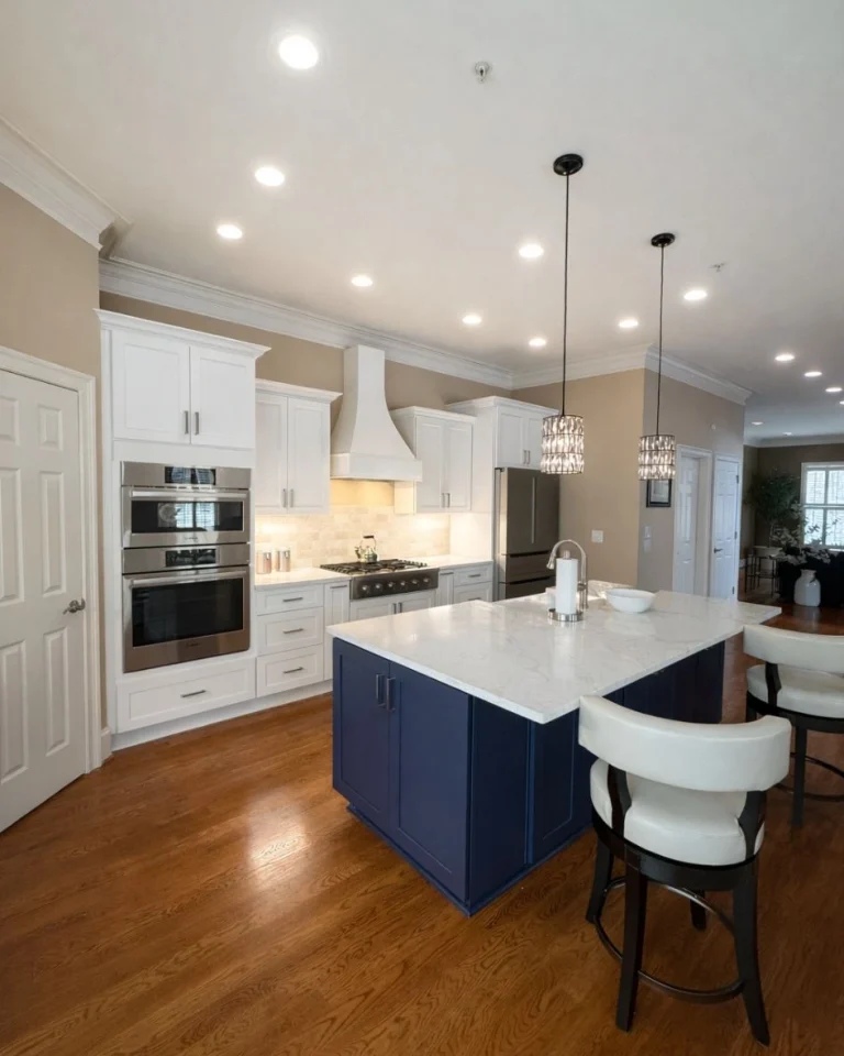 Modern kitchen remodel in Alpharetta GA by Yanover Construction featuring white cabinets, double ovens, and a custom blue island.