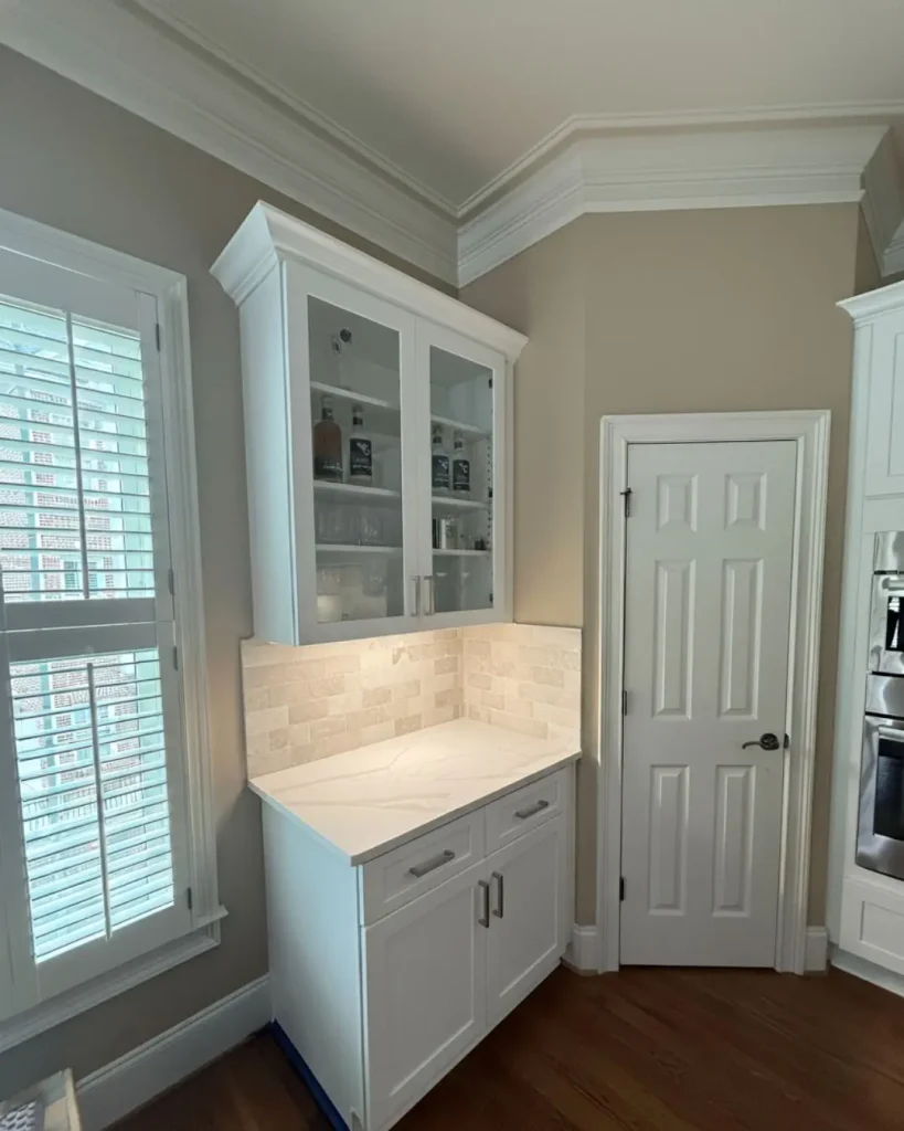 Custom kitchen remodel in Alpharetta, GA featuring built-in bar with glass cabinets and quartz countertop
