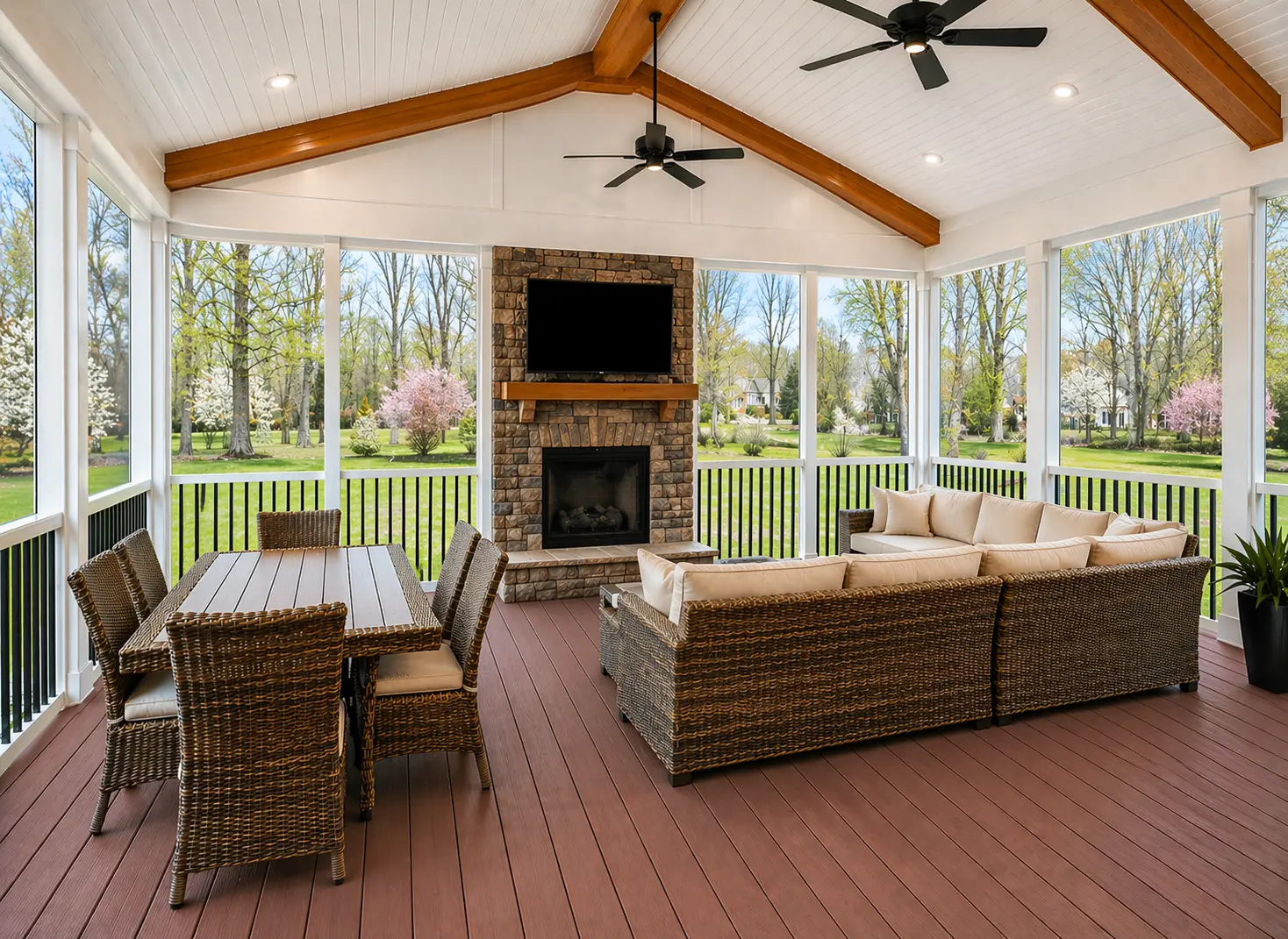 Custom covered patio in Alpharetta, GA with fireplace, vaulted wood beams, composite decking, and outdoor seating area.