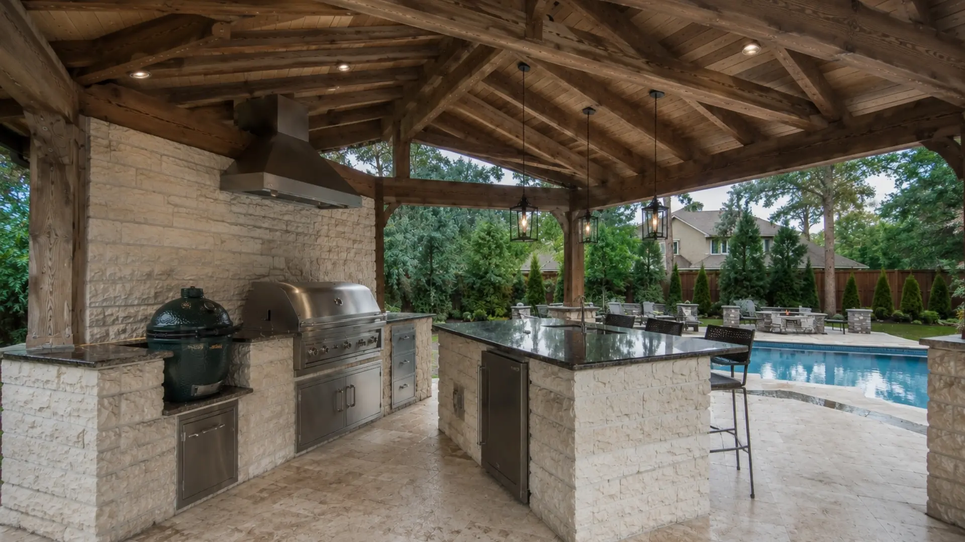 Custom outdoor kitchen pavilion with cedar beams, stone countertops, and backyard pool.