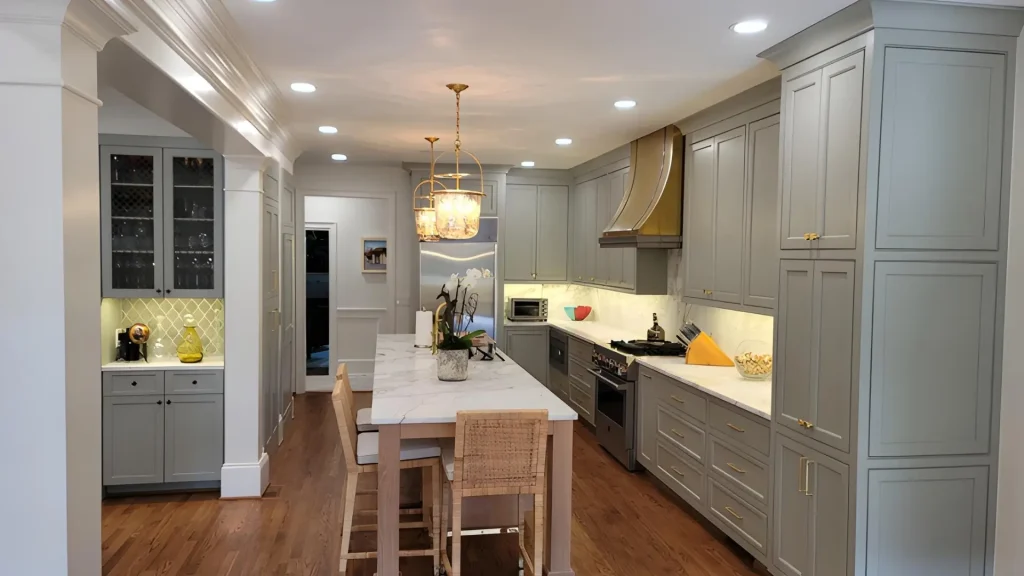 Luxury kitchen remodel in Alpharetta, GA featuring custom gray cabinetry, marble countertops, hardwood floors, and large center island.