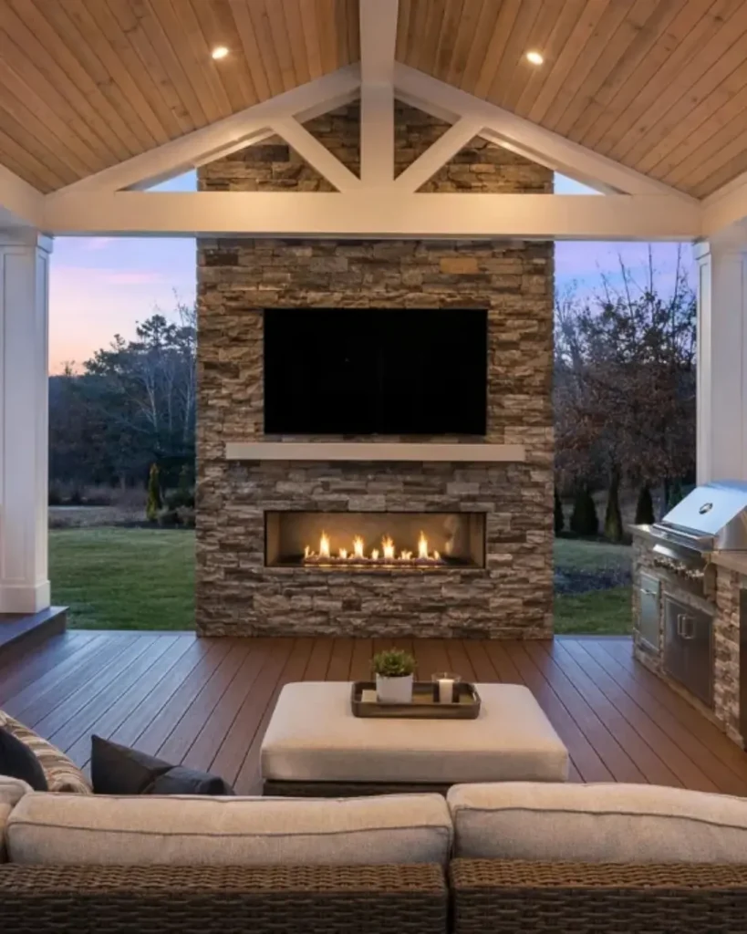 Luxury covered outdoor living space with stone fireplace, composite decking, and built-in outdoor kitchen in Alpharetta, GA.