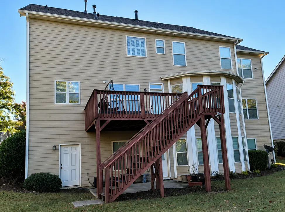 Before photo of an aging pressure-treated wood deck before replacement with a custom composite deck.