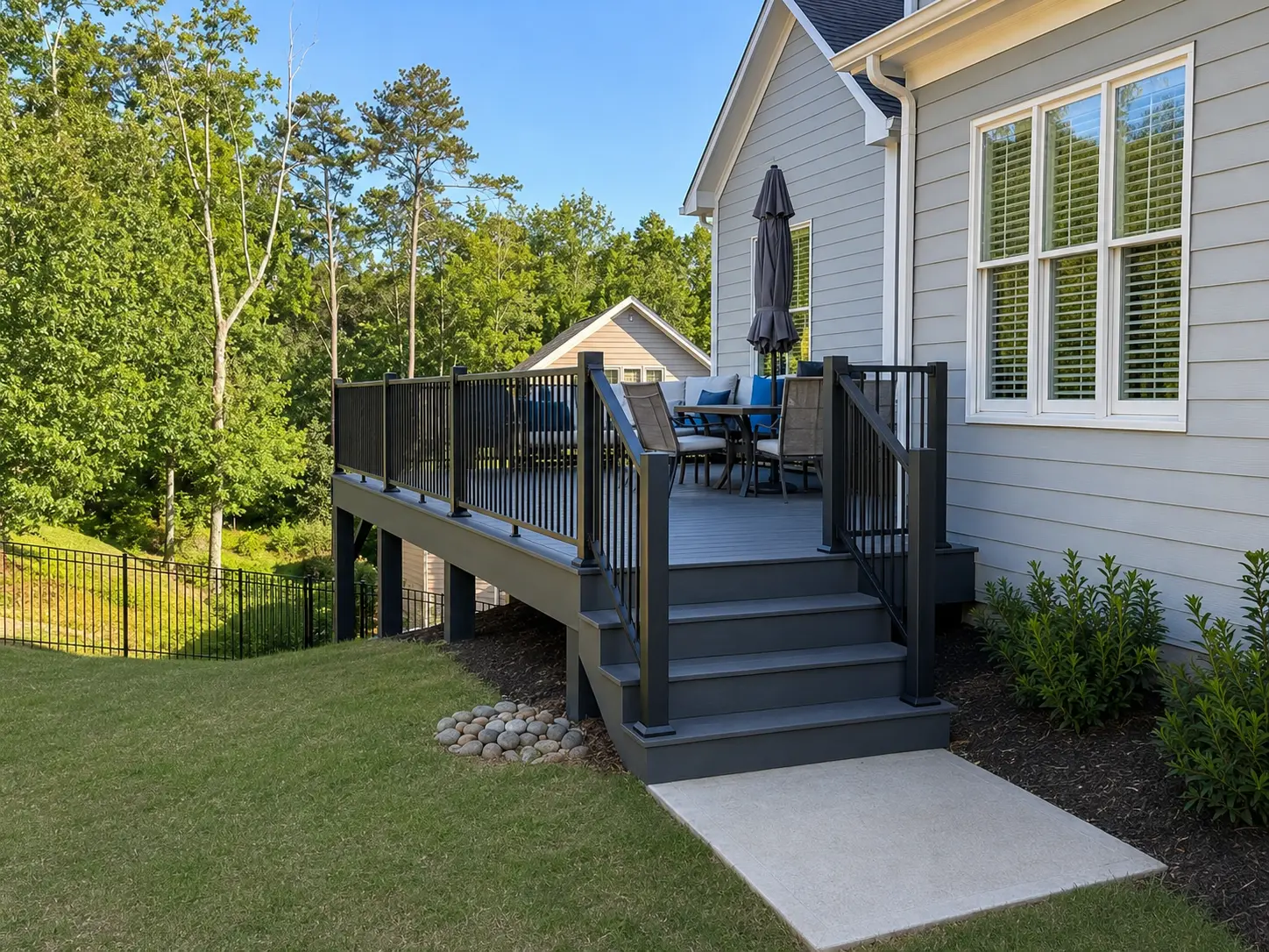 Modern composite deck replacement with black aluminum railing and upgraded outdoor living space at a North Atlanta home designed for entertaining and low-maintenance durability.