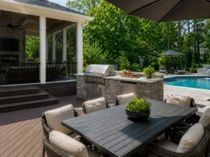 Covered outdoor living space with composite decking, outdoor kitchen, and poolside dining area in North Atlanta