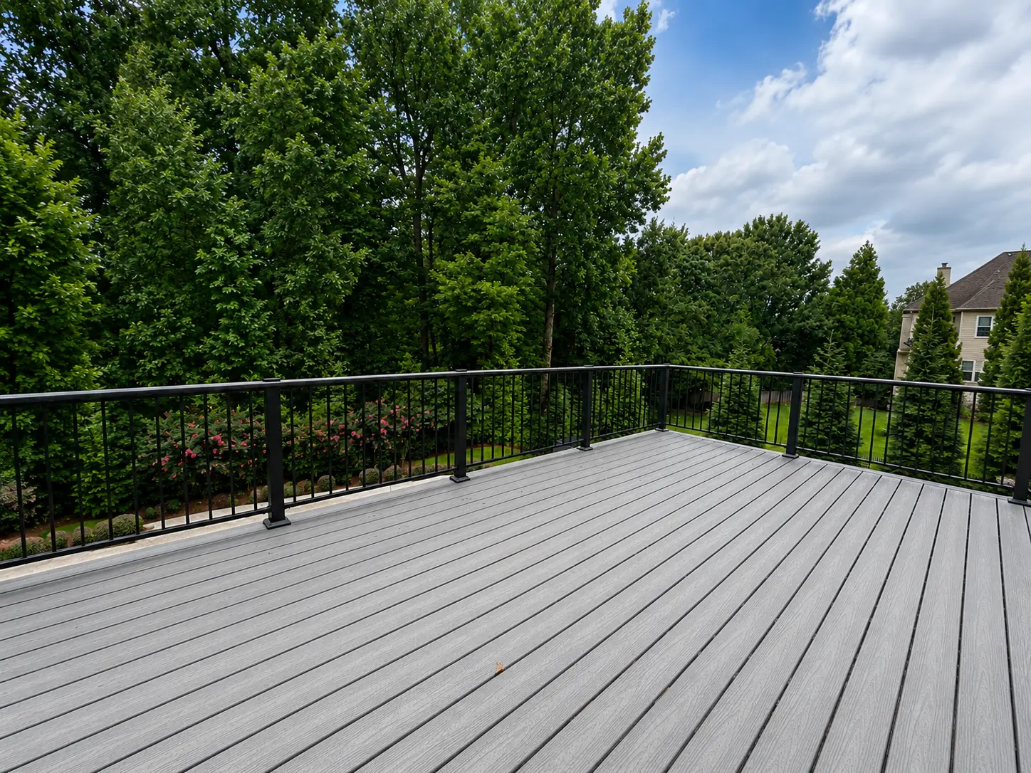 Backyard deck renovation with gray composite boards and black metal railing in Johns Creek, GA