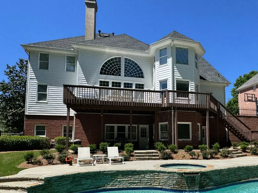 Before: Before deck replacement showing an aging elevated wood deck overlooking a backyard pool in Johns Creek, GA