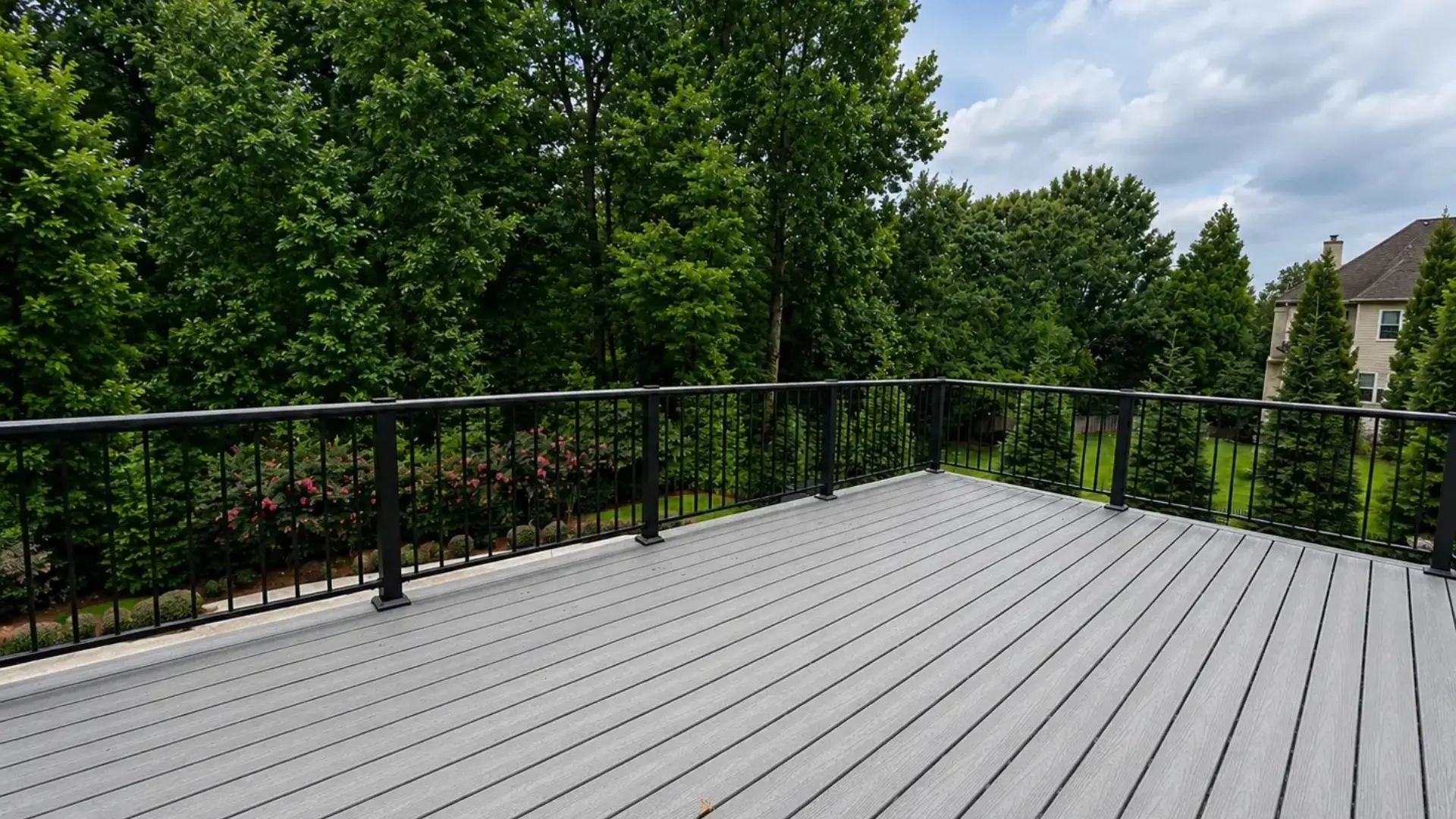 Gray composite deck with black aluminum railings overlooking a landscaped North Atlanta backyard.