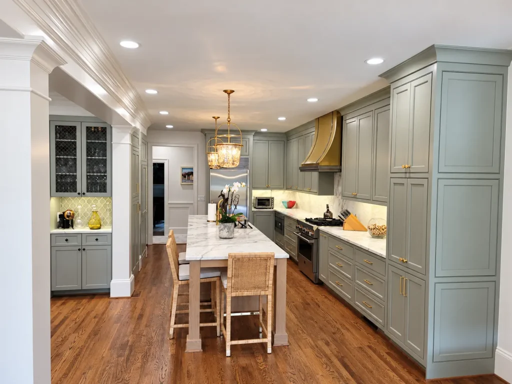 Custom kitchen remodel in Buckhead, GA with gray cabinetry, large island, stone countertops, and hardwood floors.