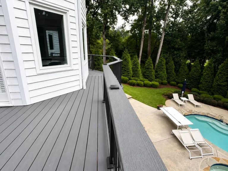 Poolside deck remodel with gray composite decking and black railings in Johns Creek, GA