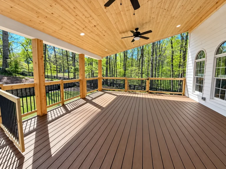 Trex composite deck with covered porch, tongue-and-groove pine ceiling, wood railing and black aluminum balusters in Alpharetta, GA.