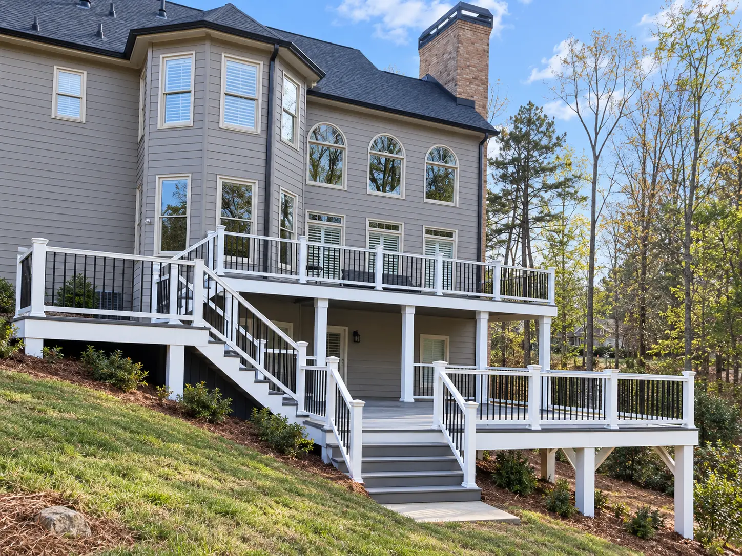 Rebuilt multi-level Trex deck with white posts, black railing, stairs, and expanded outdoor living space in Milton, GA.