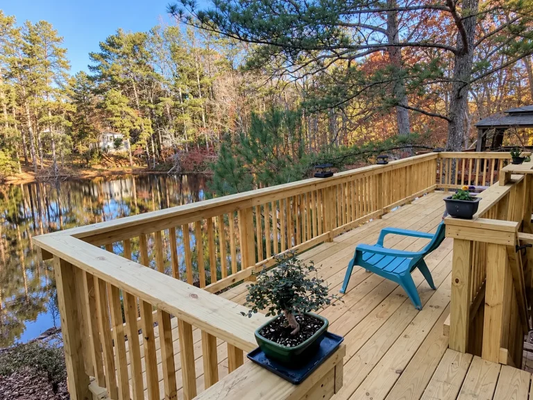 Custom wood deck with natural wood decking and railings overlooking a wooded lake in North Atlanta, GA.