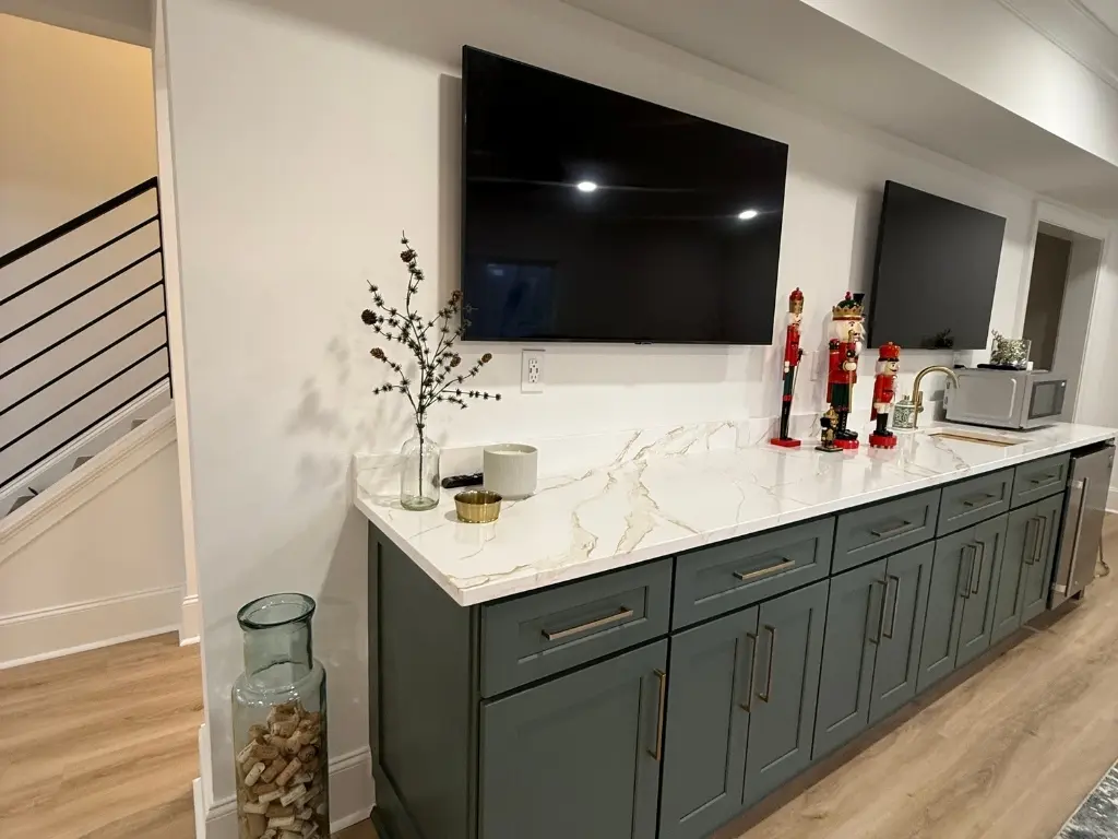 Custom basement bar with dark cabinetry, quartz countertop and entertainment area in North Atlanta