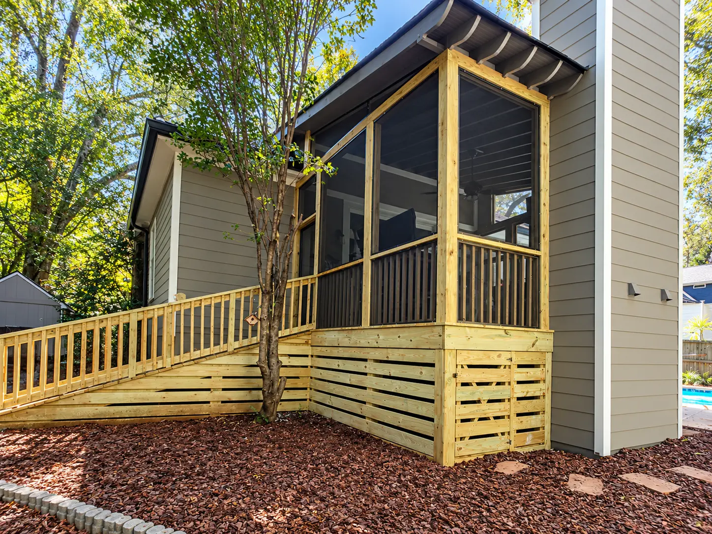 After: Exterior view of an elevated screened porch and deck.