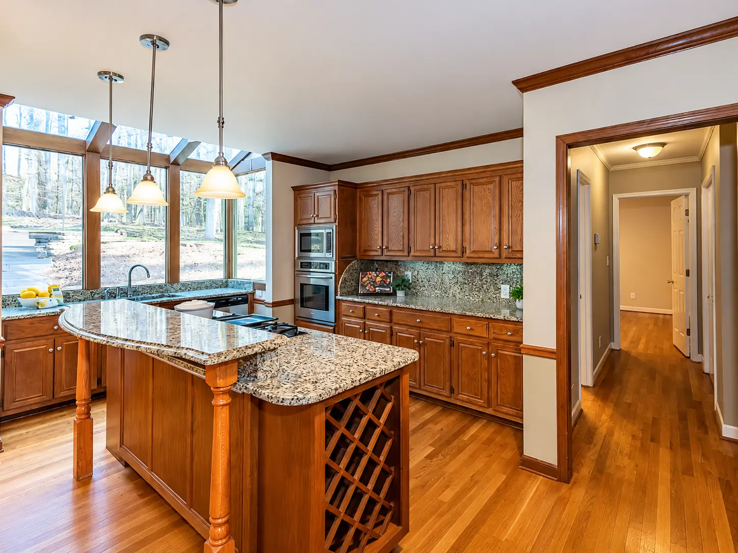 Before: Traditional kitchen before remodeling in North Metro Atlanta, featuring dark wood cabinetry, granite countertops, and a two-level island.