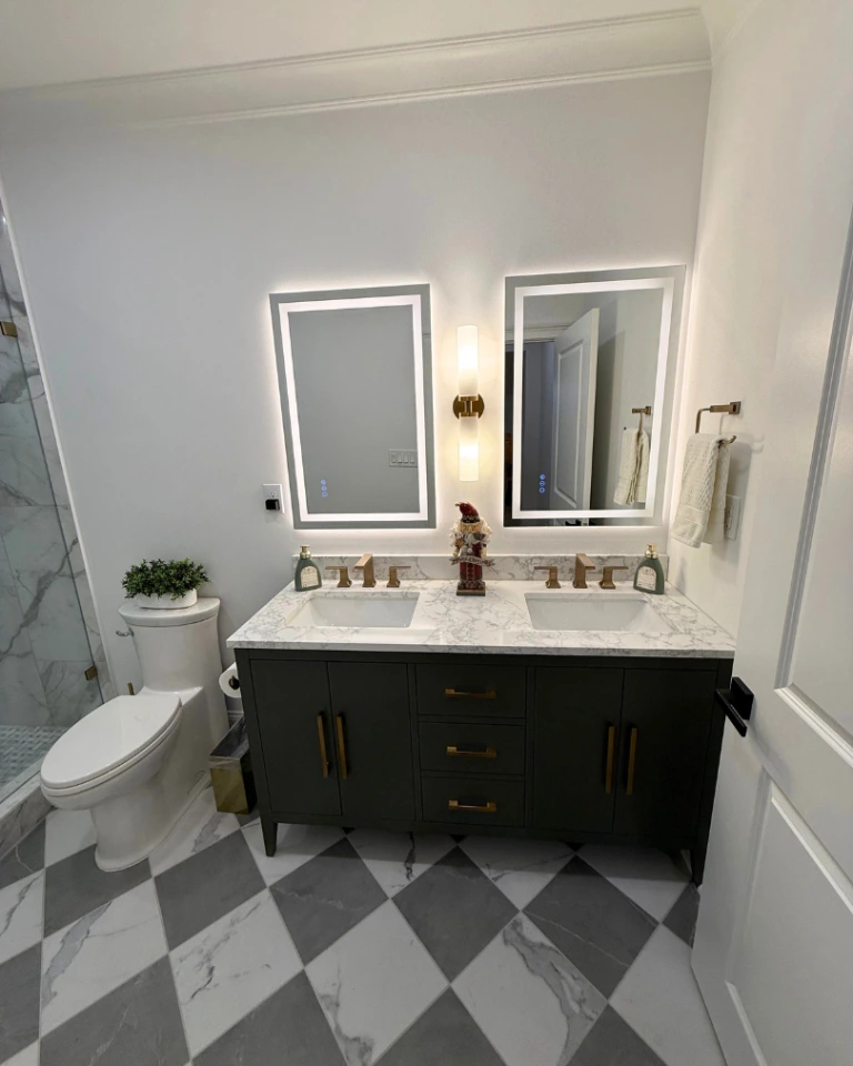 Luxury basement bathroom with double vanity, illuminated mirrors, and marble tile in Alpharetta, GA.