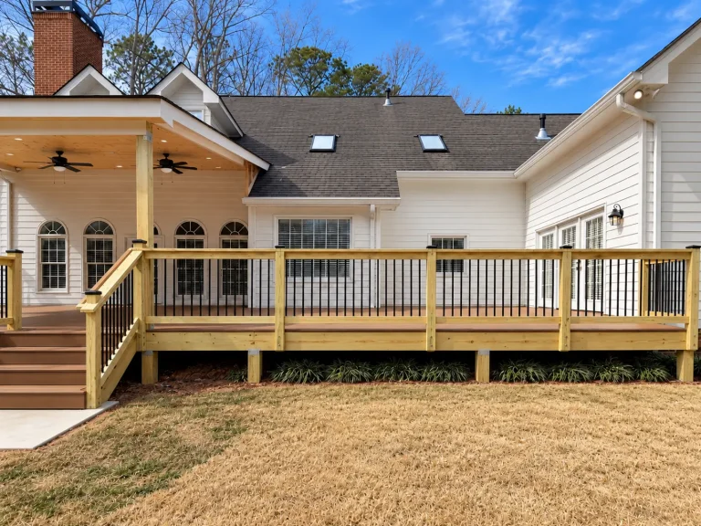 Custom deck and covered porch with composite decking and black railings in Alpharetta, GA